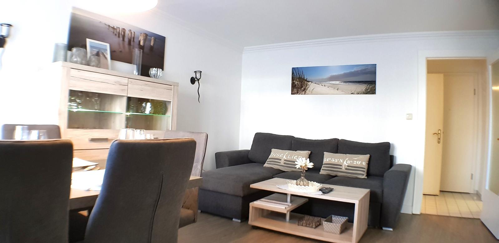 Wohn- und Essbereich mit Sofa, Couchtisch und Sideboard.