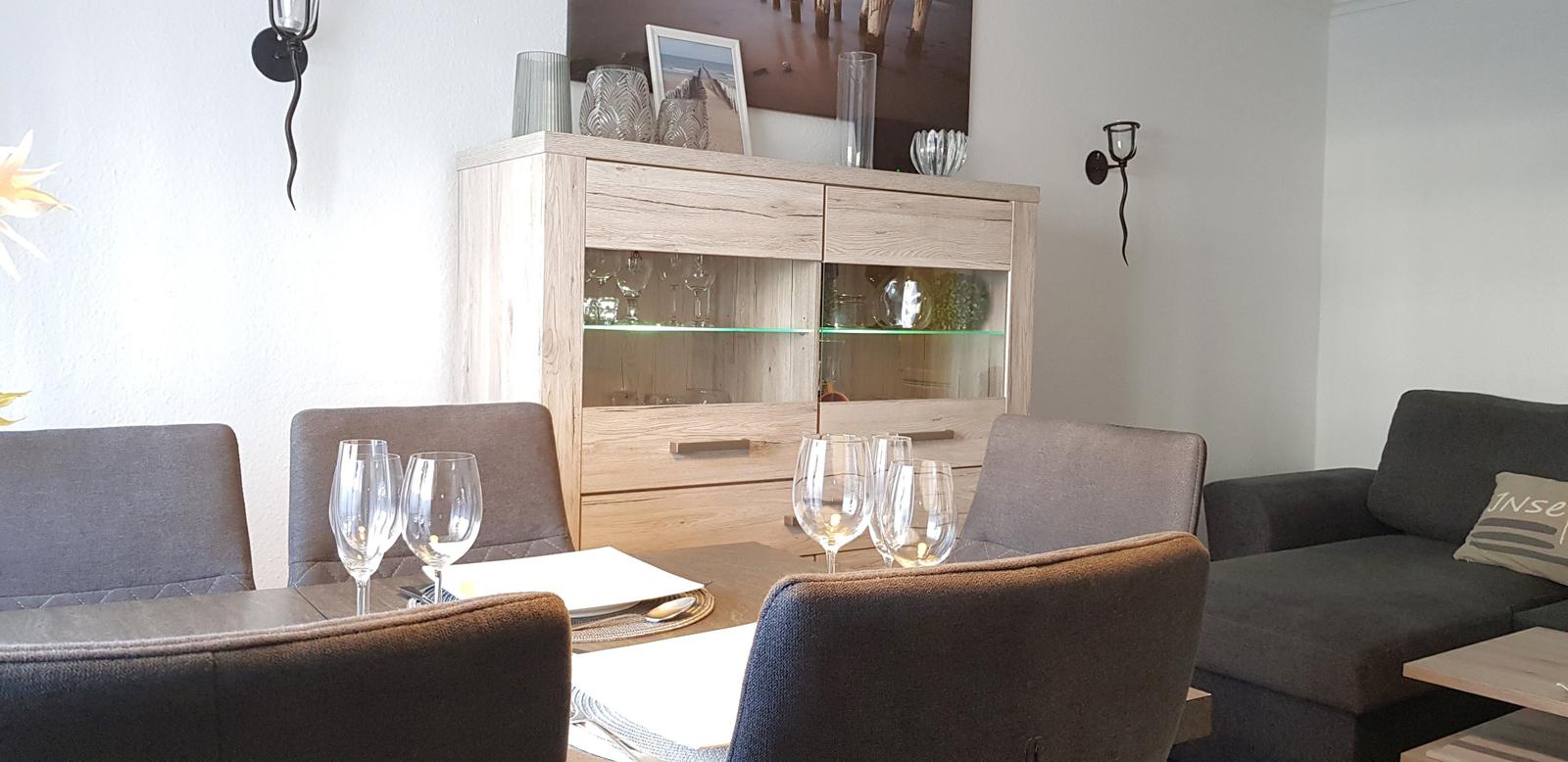 Esstisch mit Stühlen und Sideboard im Wohnbereich.