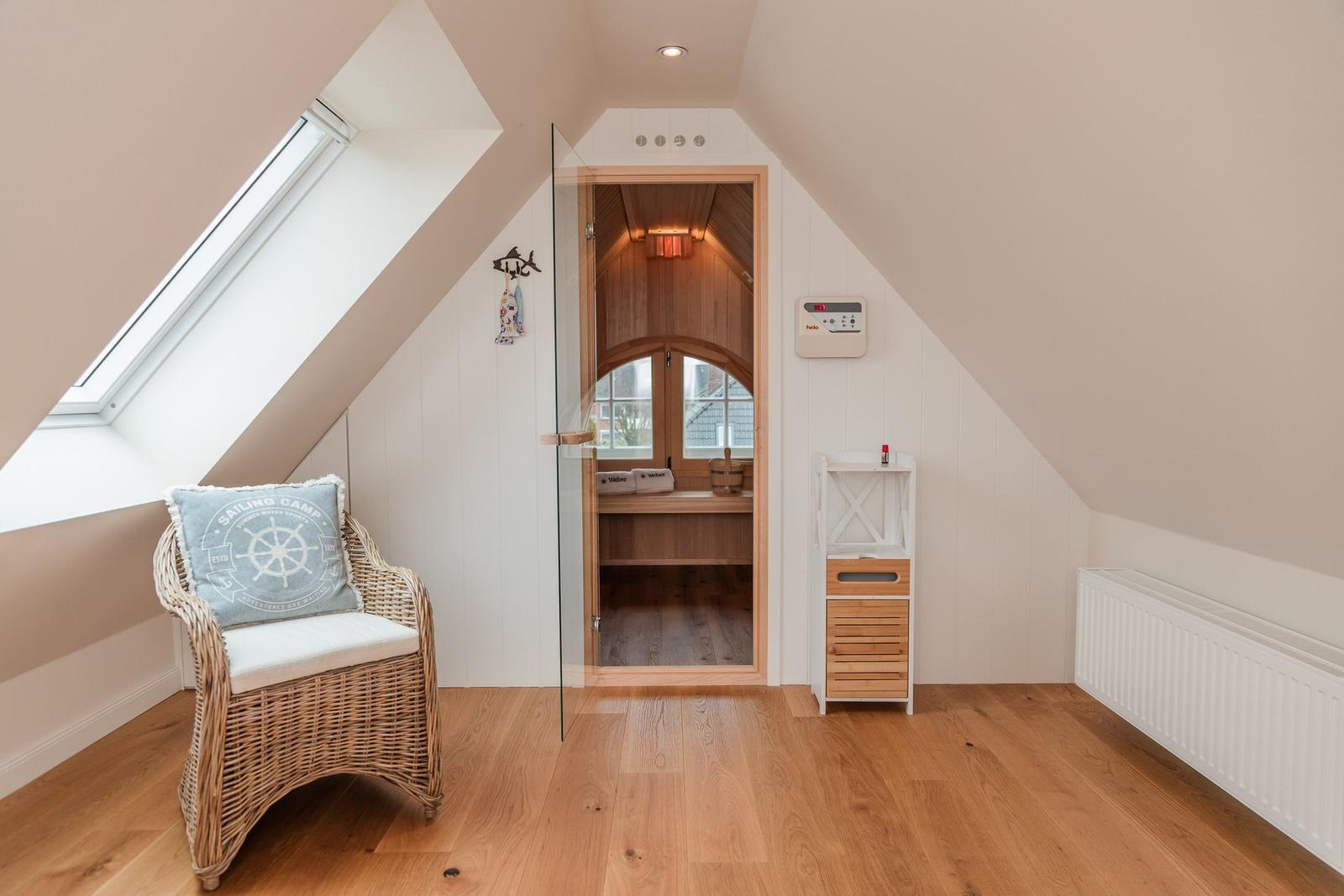 Dachgeschosszimmer mit Sitzgelegenheit und Sauna