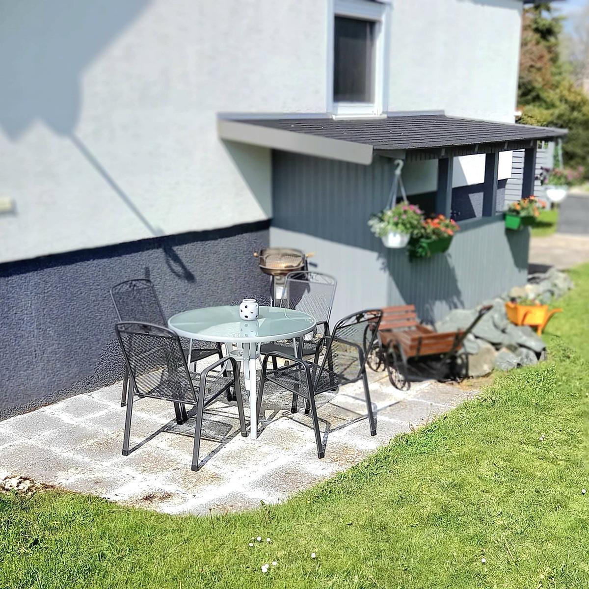 Sitzecke mit Grillmöglichkeiten. Ein größerer Tisch steht zur Verfügung.