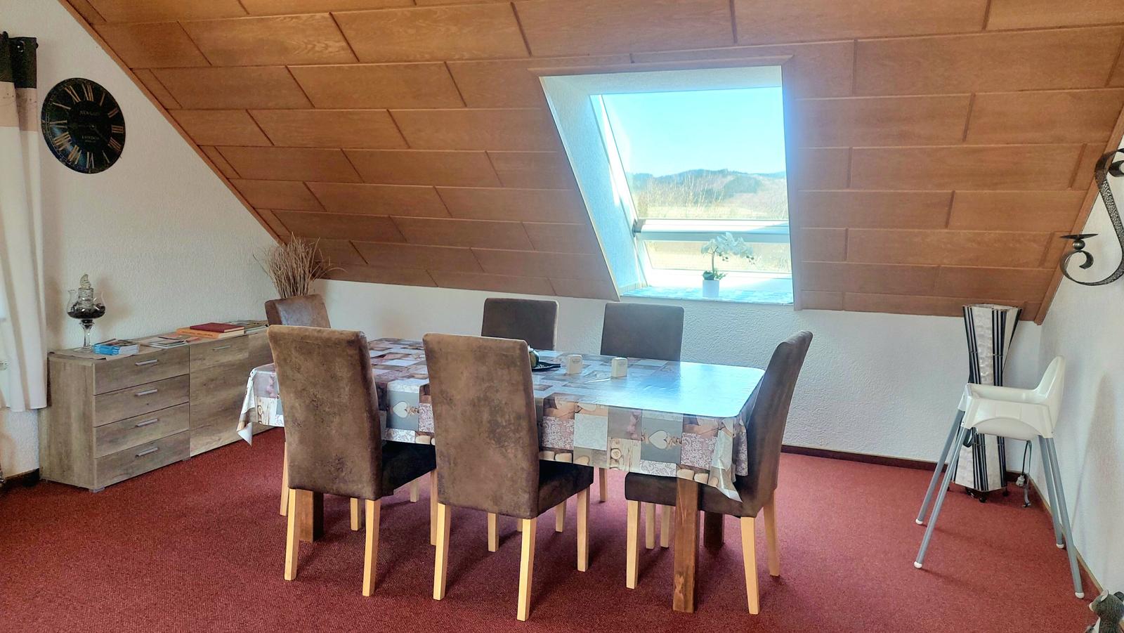 Esszimmer mit Sitzgruppe, Fenster und Holzdecke