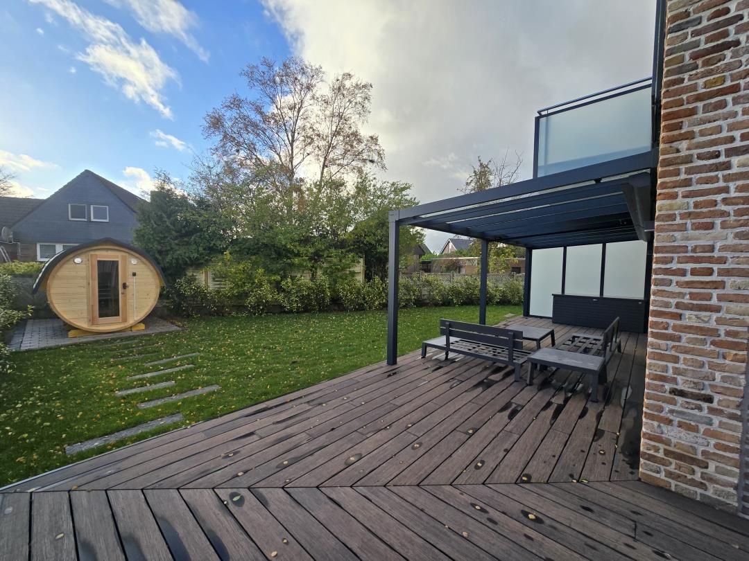 Terrasse mit Sitzgelegenheit und Sauna im Garten