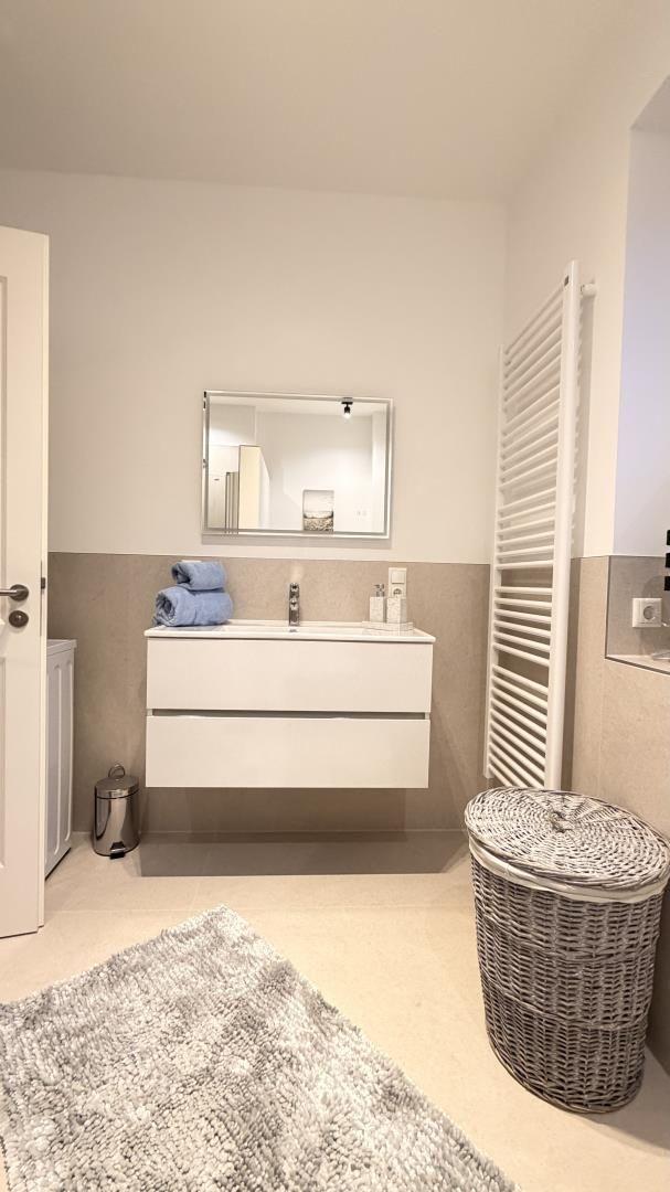 Badezimmer mit Waschbecken, Spiegel und Heizkörper