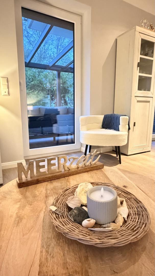 Wohnbereich mit Sitzgelegenheit und Blick auf Terrasse. Dekoration mit Meeresmotiven.