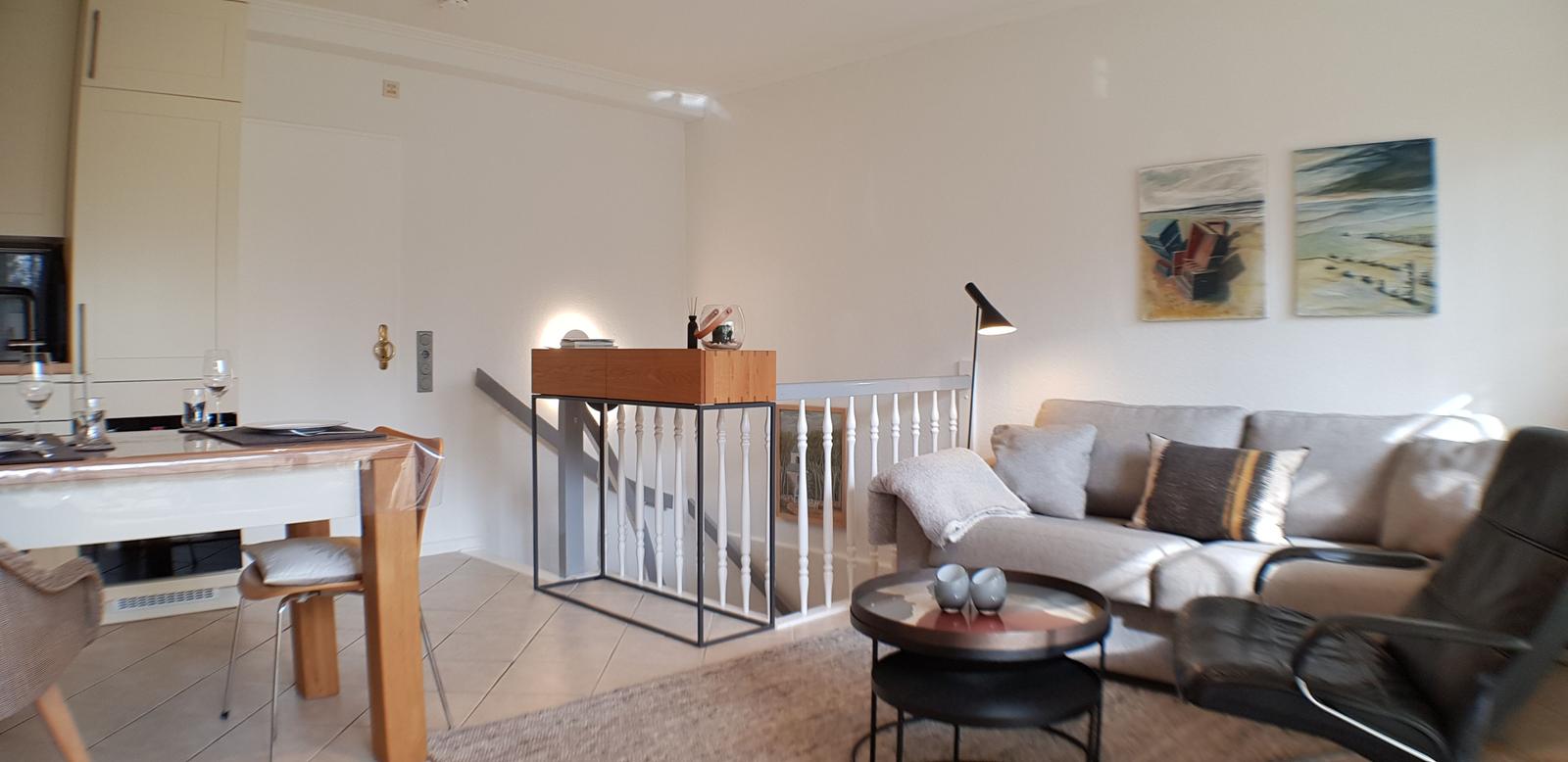 Wohn- und Essbereich mit Sofa, Tisch und Küchenzeile.