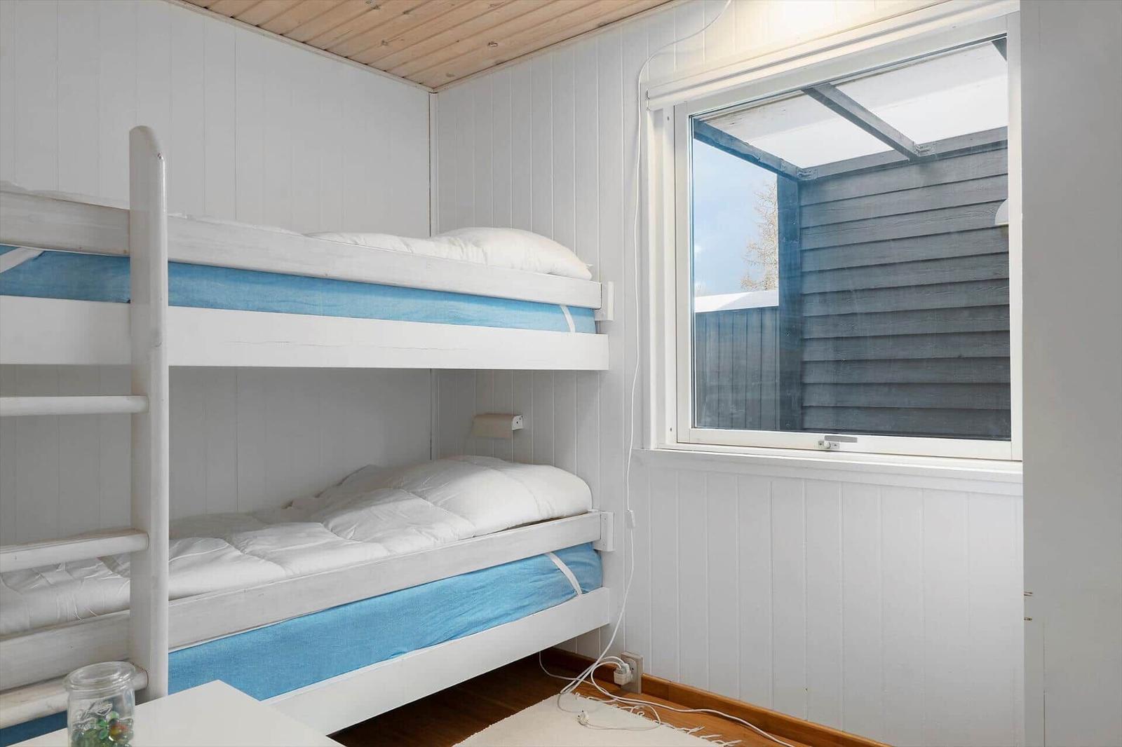 Zimmer mit Doppelstockbett und Fenster zur Außenseite.