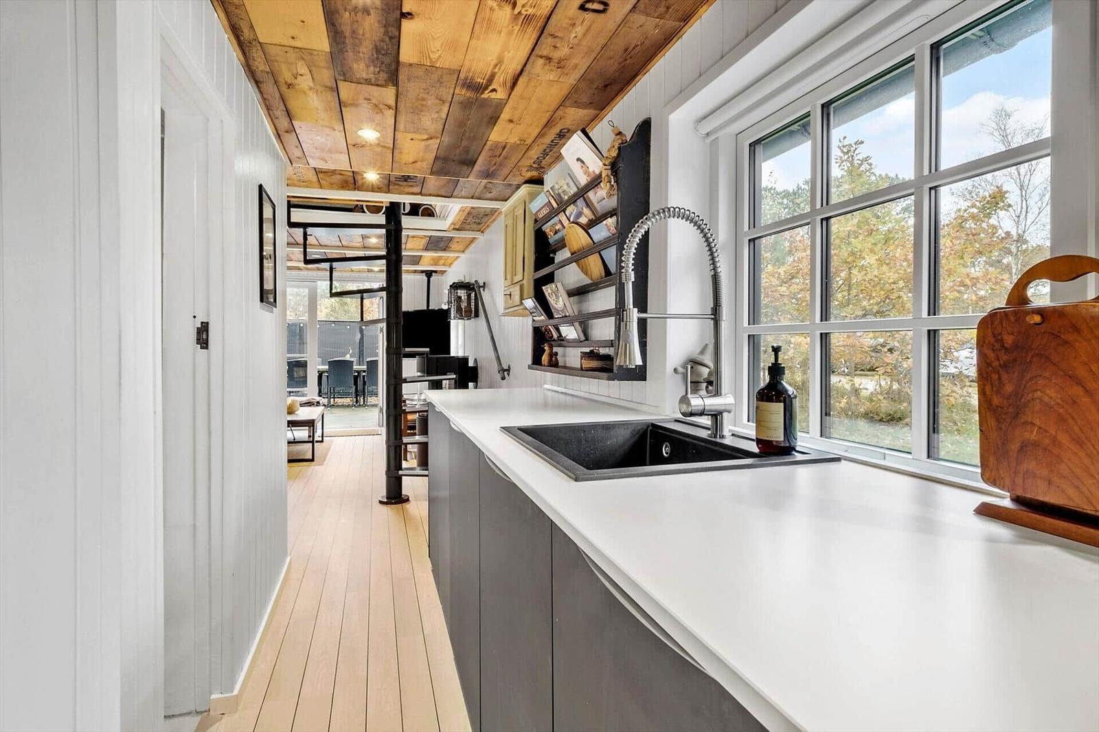 Küche mit Arbeitsplatte, Spüle und Fenster zum Blick auf den Garten.