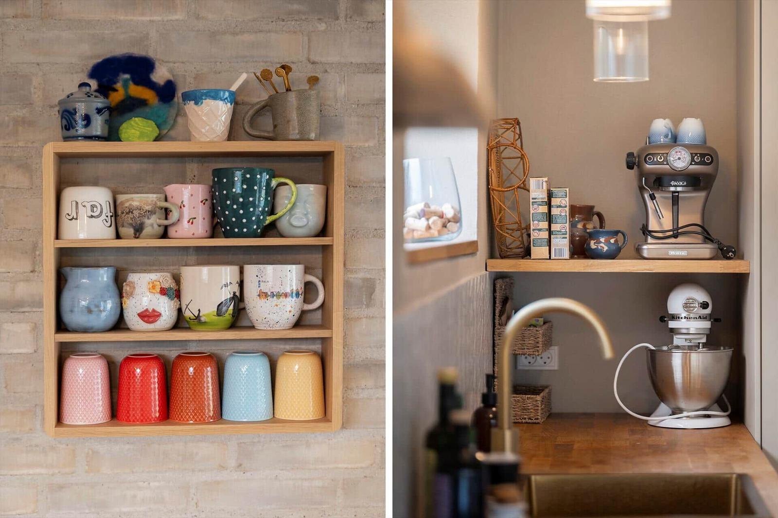 Kitchen area with espresso machine and mixer. Wall shelf with colorful mugs.