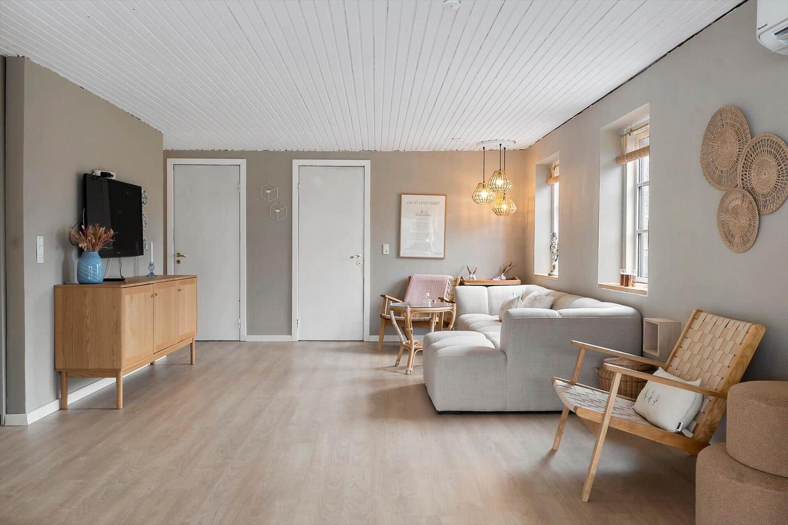 Living room with sofa, chair, and TV on wall