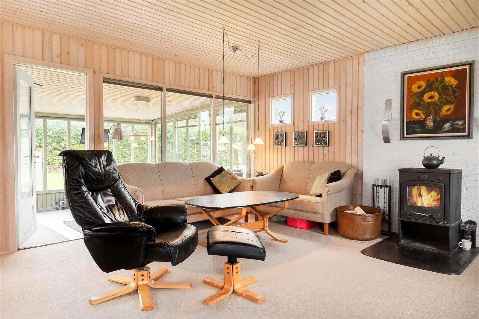 Living room with seating group, wood stove, and large window area.