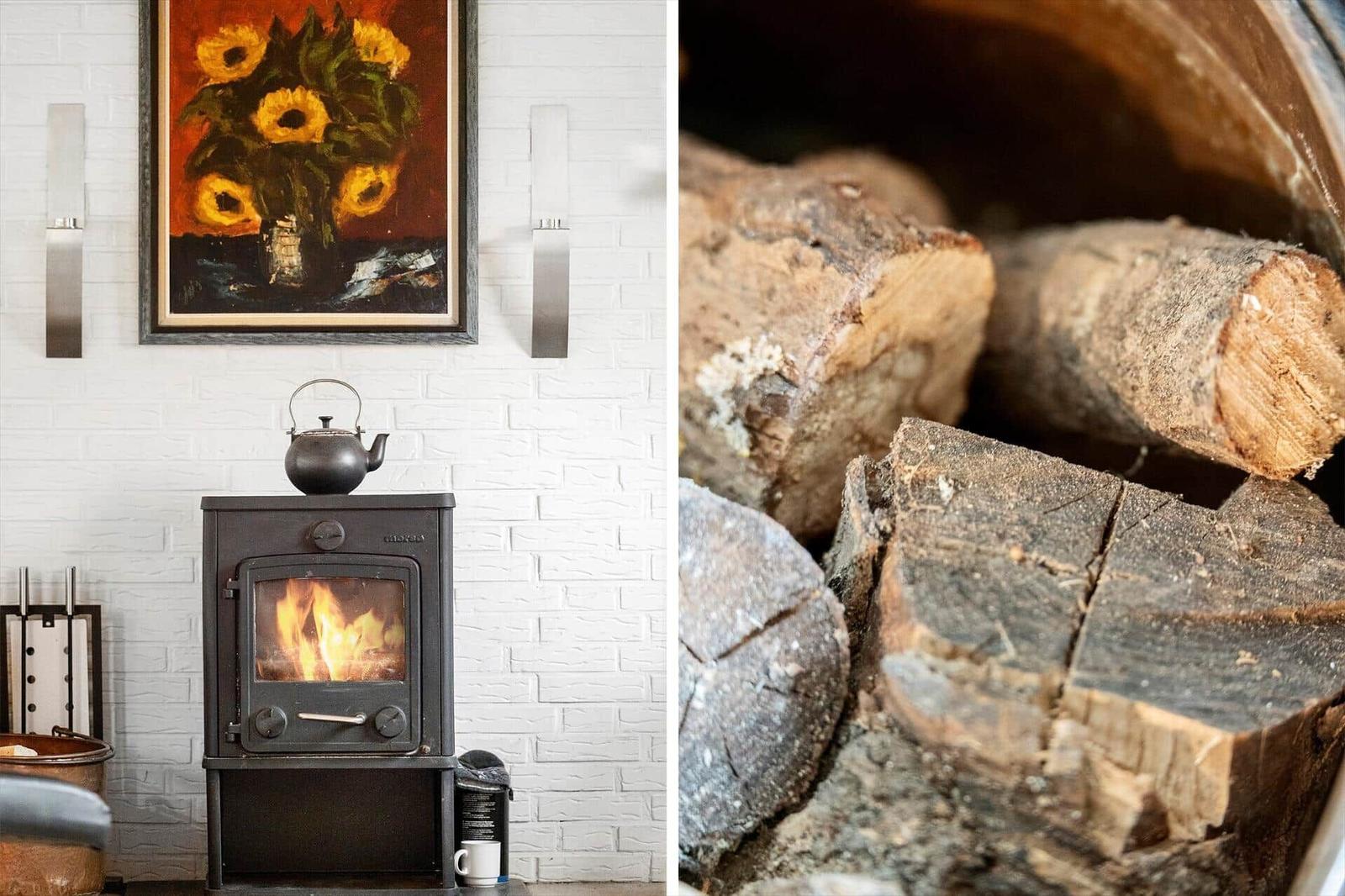 Wood stove with kettle and firewood in fireplace area