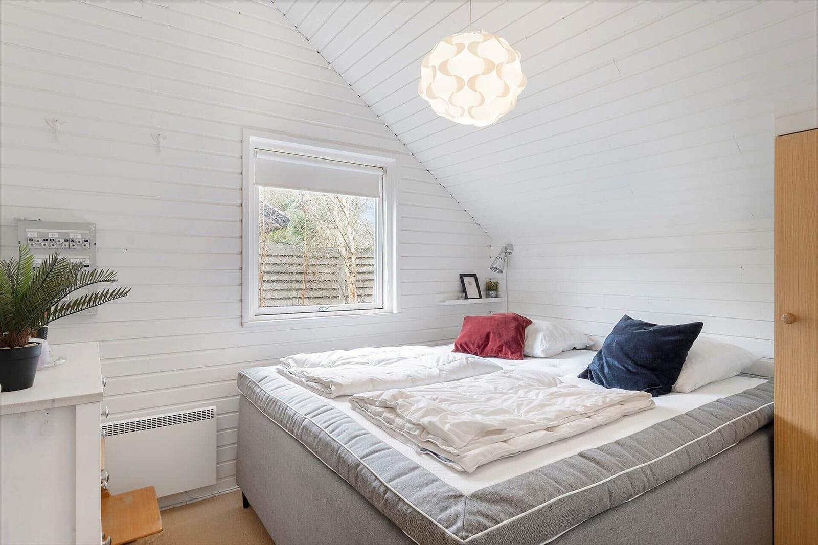 Bedroom with bed, window, and ceiling light.