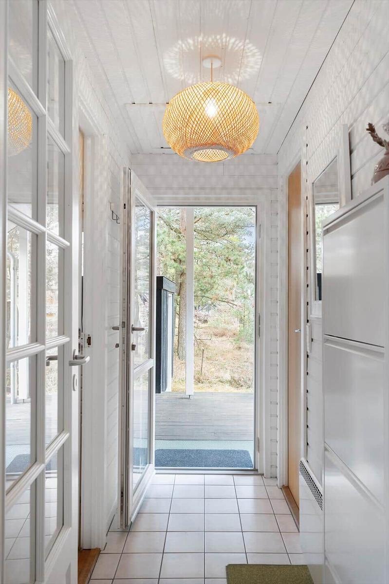 Hallway with white walls, tiled floor, and ceiling light. Corridor to the terrace.