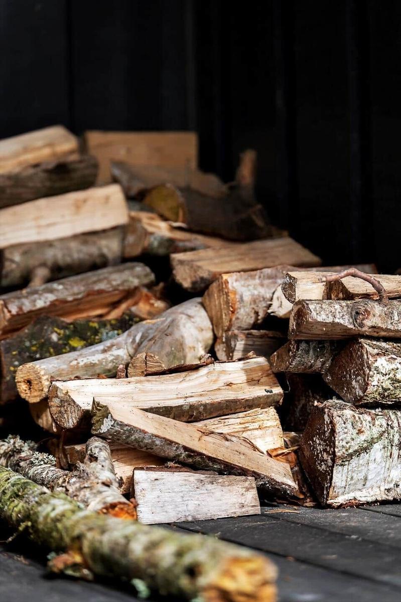 Stack of split firewood on a wooden deck.