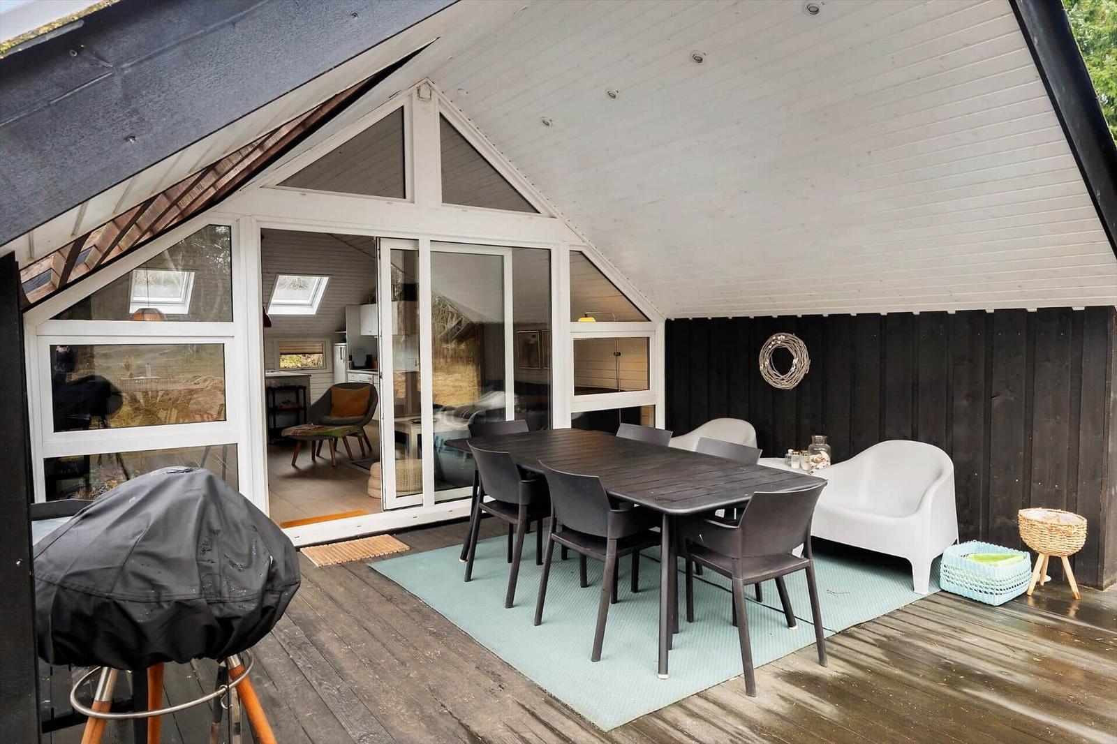 Deck with table, chairs, and seating. Access to the interior of the house.