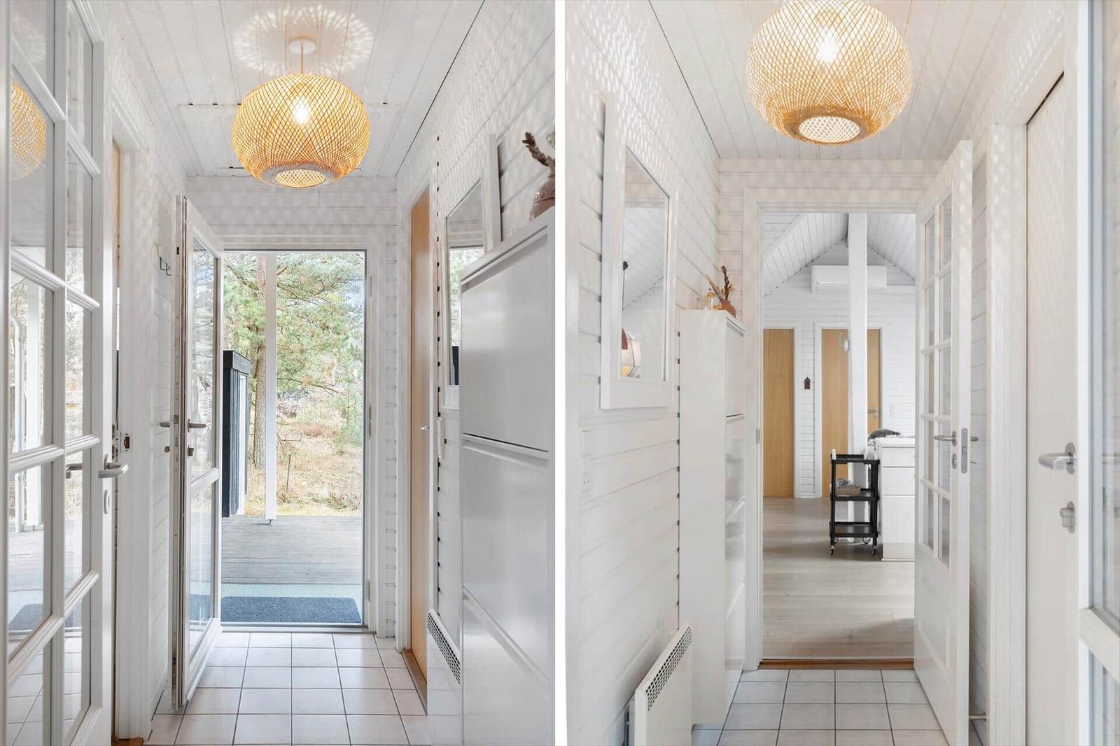Hallway with white walls, wooden floor, and round ceiling lights.