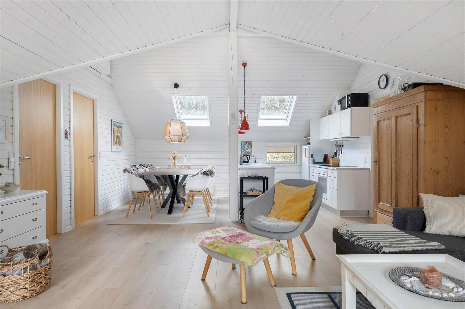 Living area with dining space, kitchen, and sleeping area under a roof