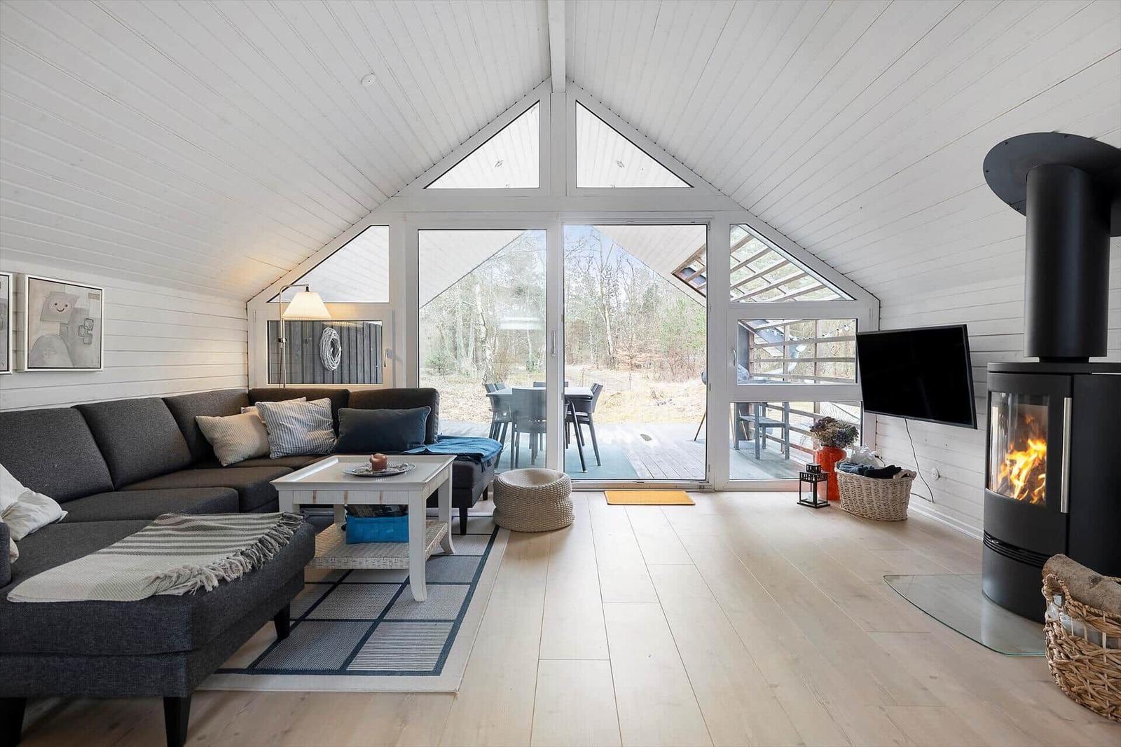 Living room with sofa, fireplace, and glass door to terrace.
