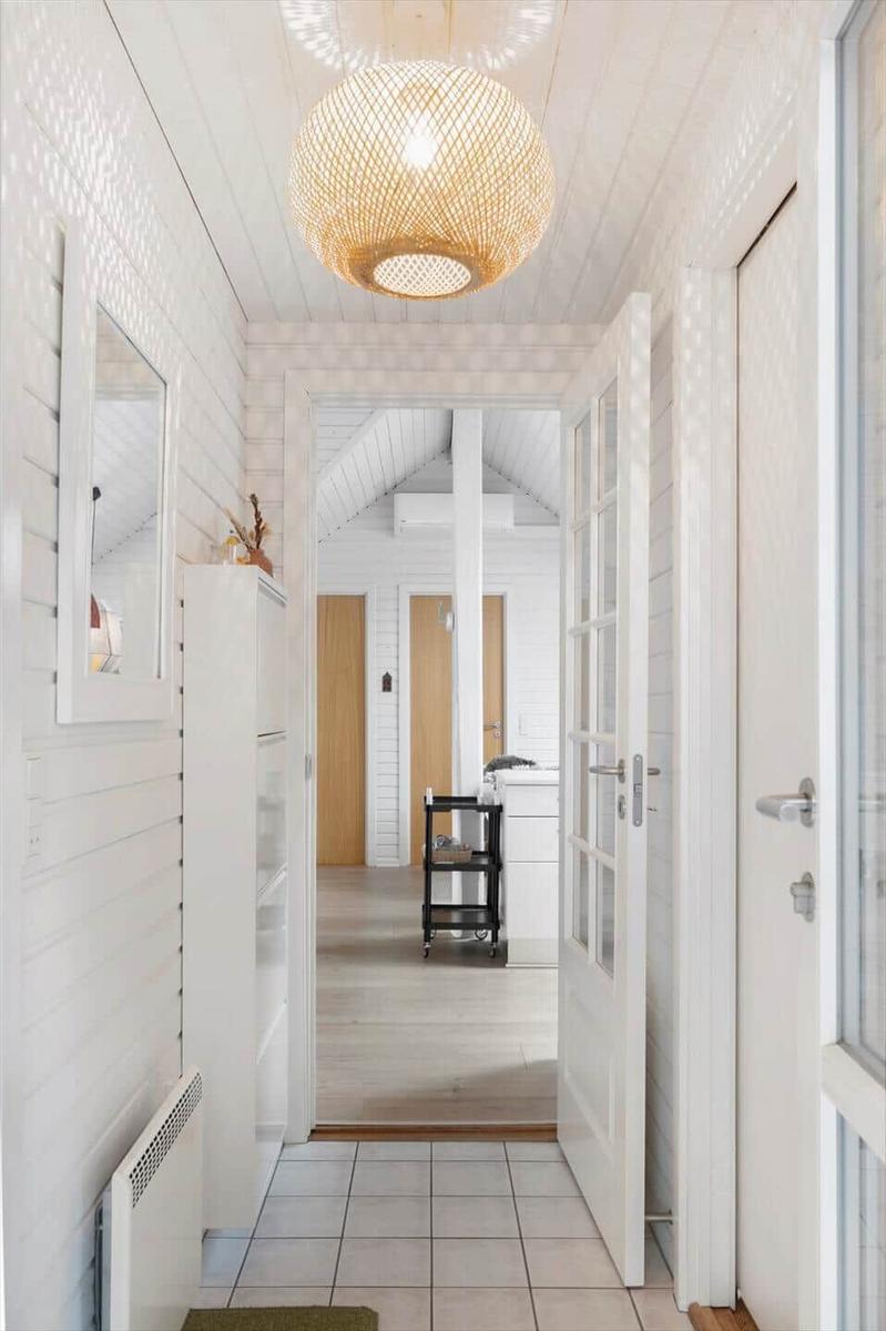 Hallway with white walls, wooden floor, and a round ceiling lamp.