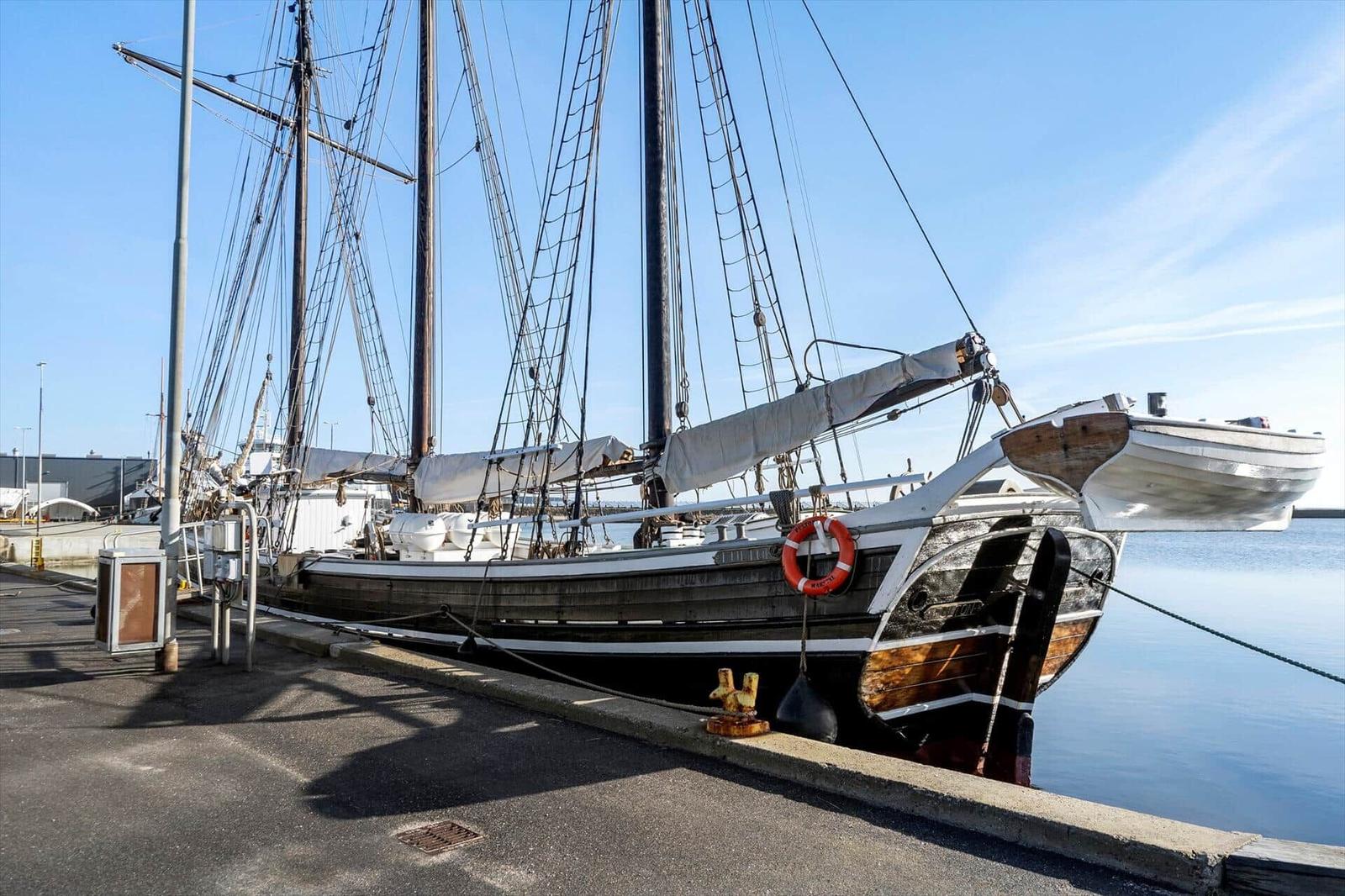 Segelschiff am Hafen mit Rettungsring und Masten.