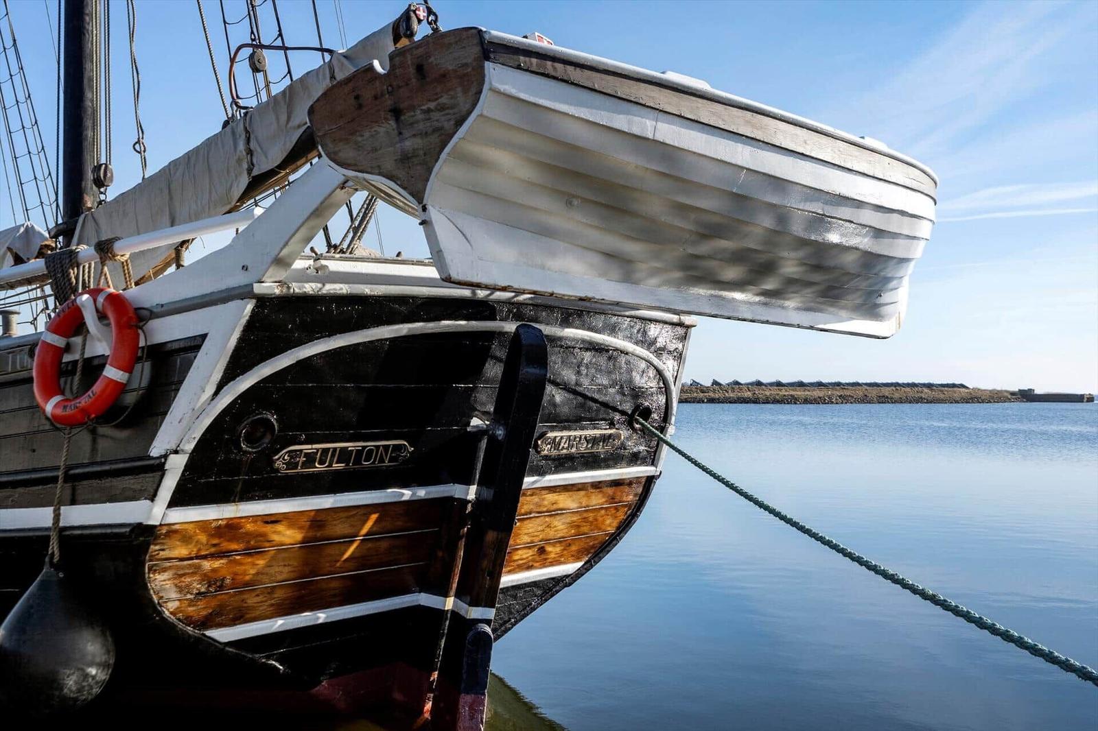 Historisches Segelschiff Fulton liegt im Hafen mit Rettungsring und Boot.