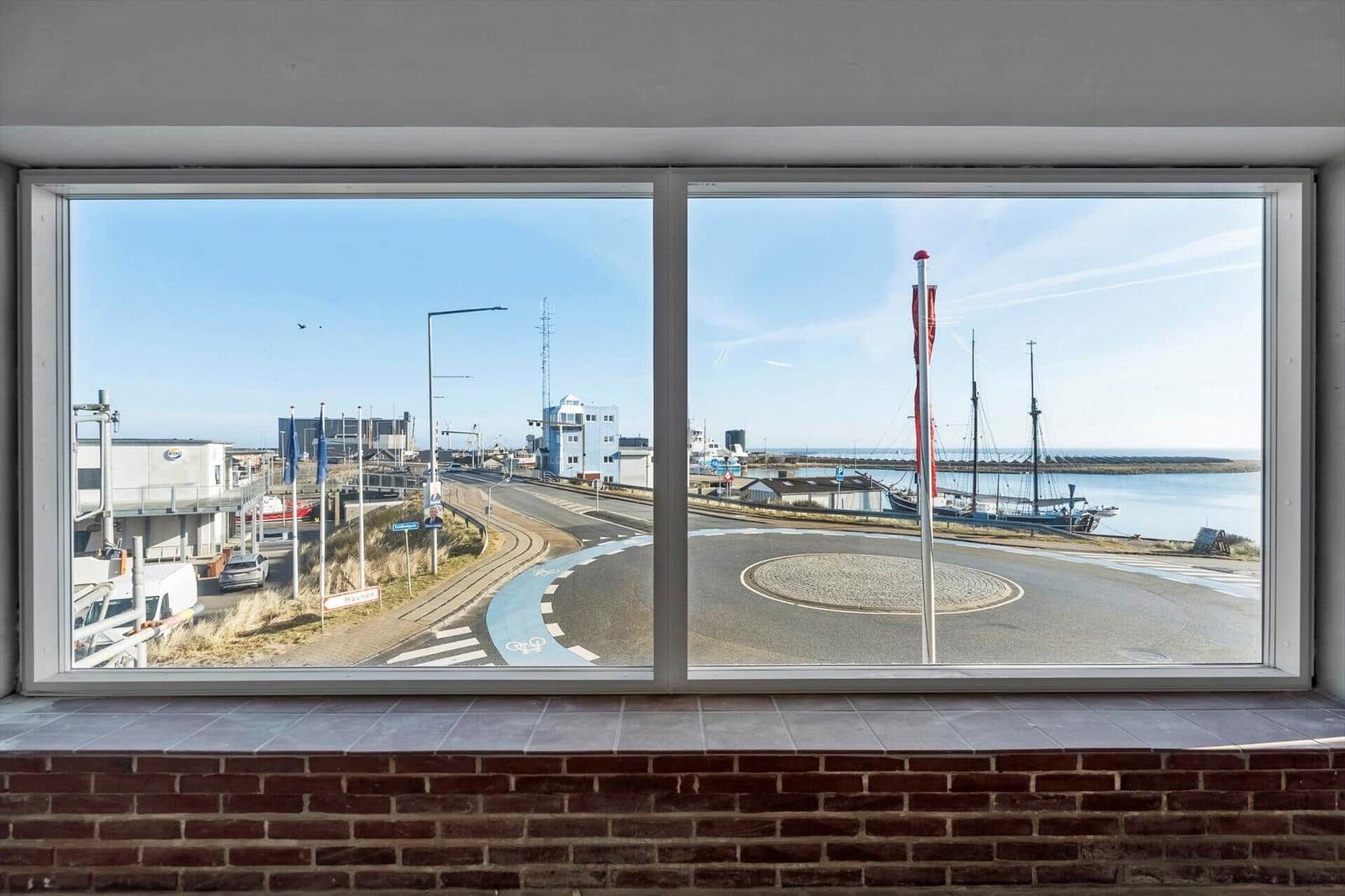 Großes Fenster mit Blick auf Hafen und Straßenkreuzung.