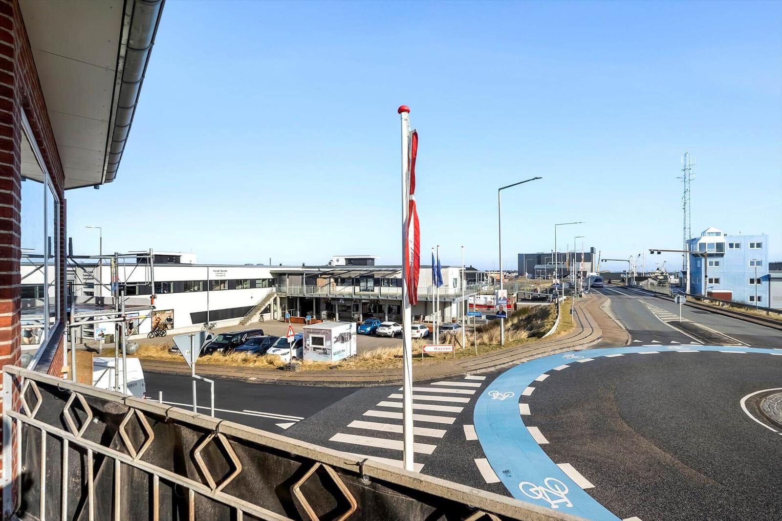 Blick auf eine Straße mit Fahrradweg und Gebäudekomplex.