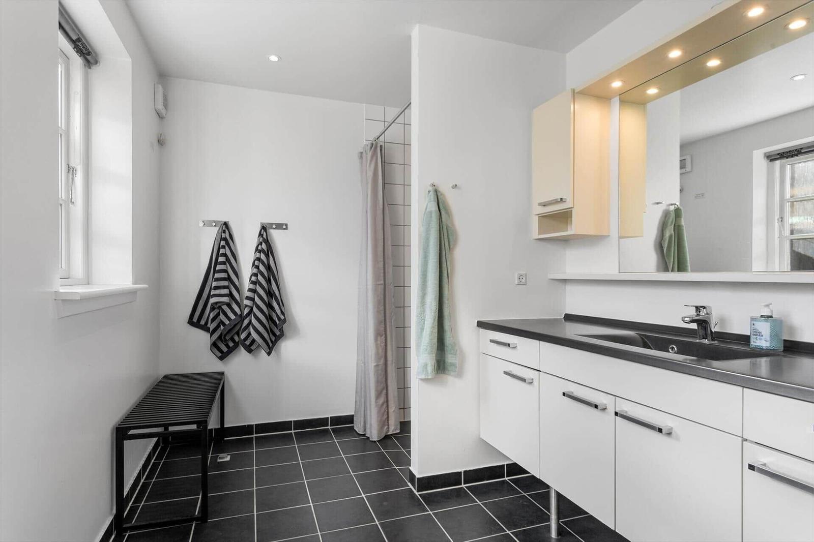 Badezimmer mit Dusche, Waschbecken und Fenster