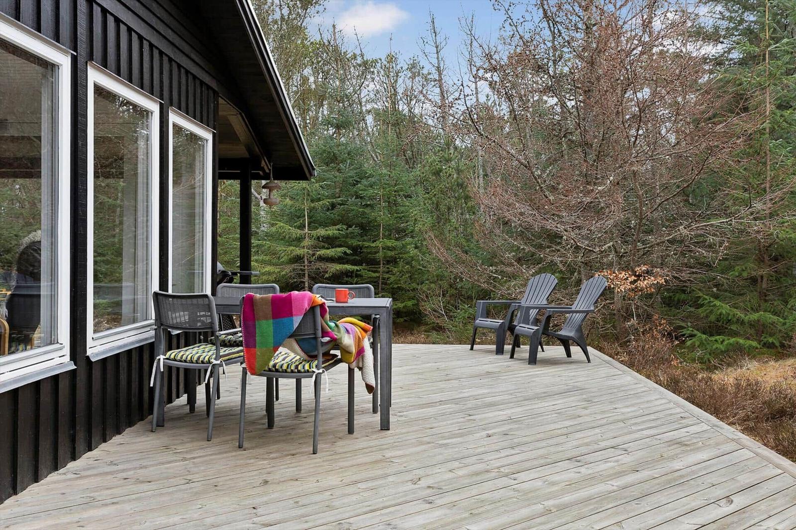 Deck with table, chairs, and view into the forest