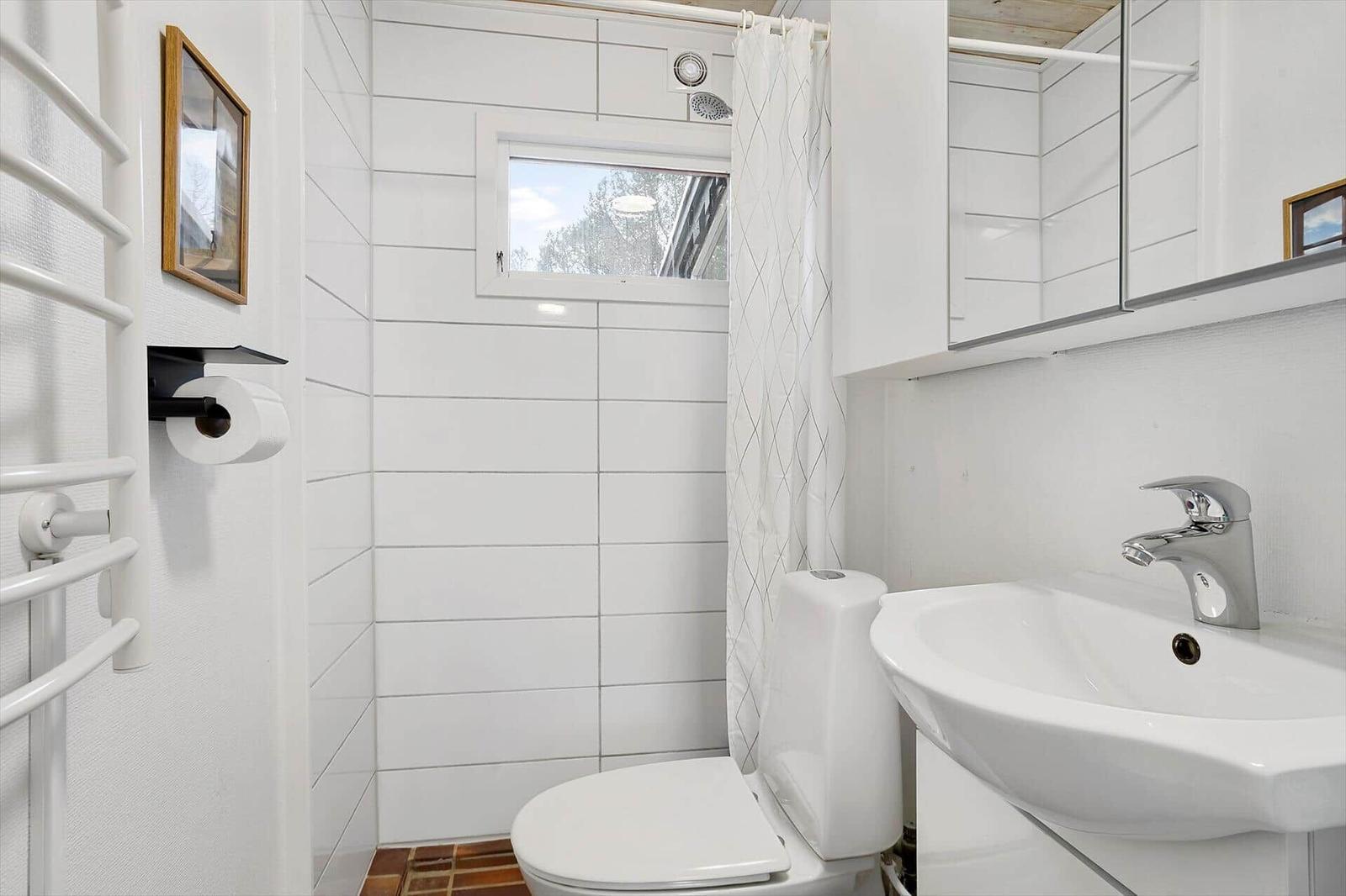 Bathroom with toilet, sink, and shower with curtain.