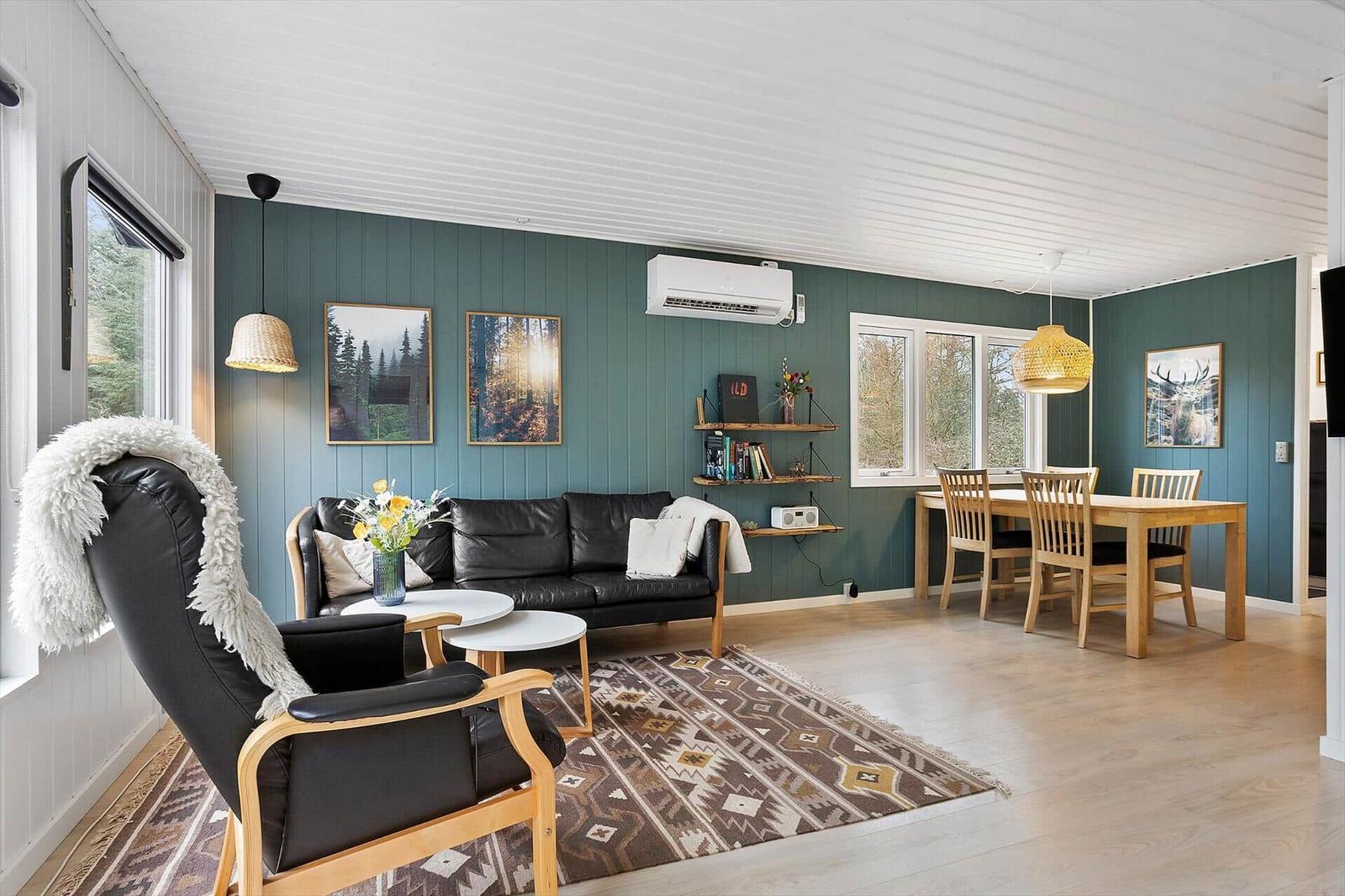 Living and dining area with sofa, chair, table, and wall art.