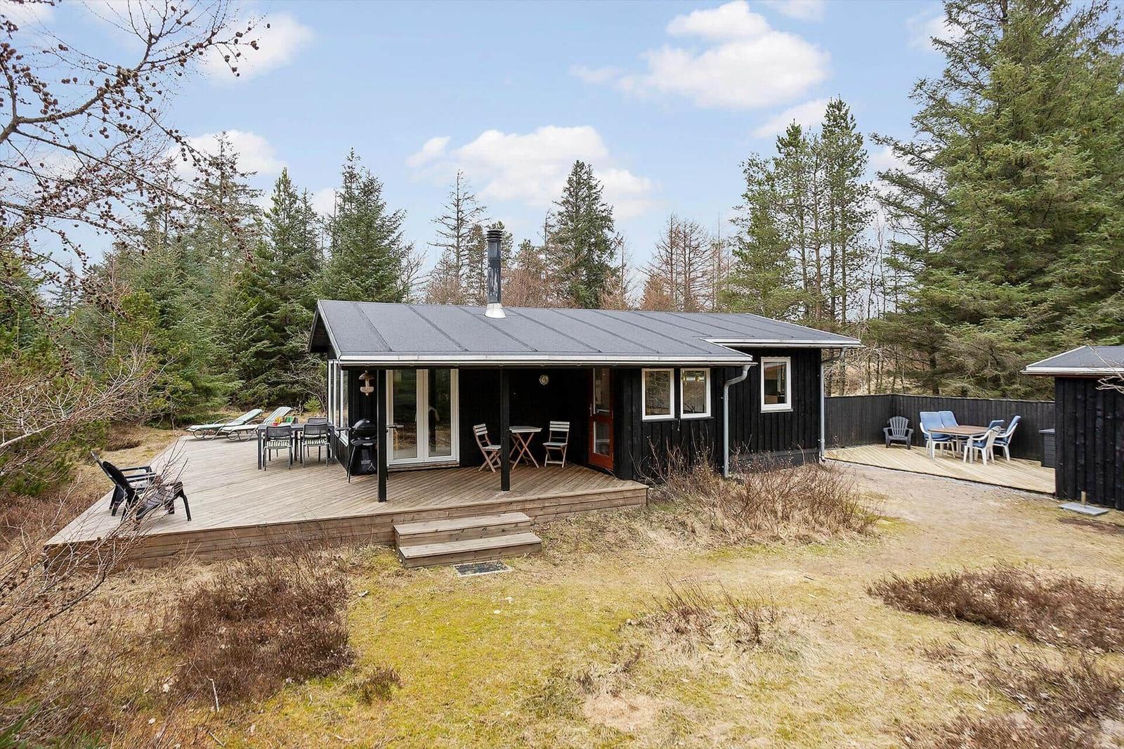 Black cabin with deck and garden. Grill and seating available.