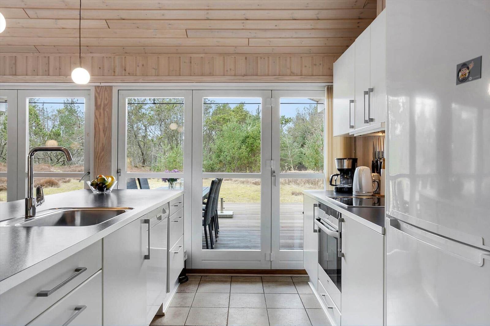 Modern kitchen with white cabinets and view of terrace