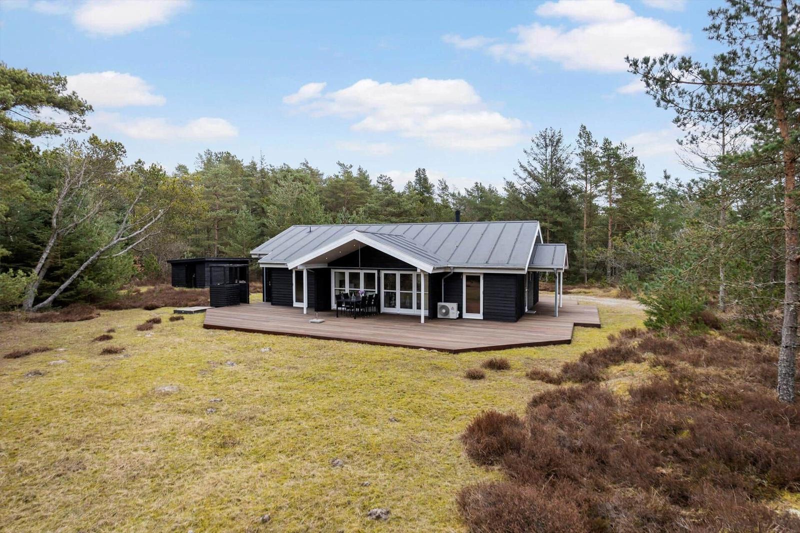 Modern wooden cabin with terrace in forest area