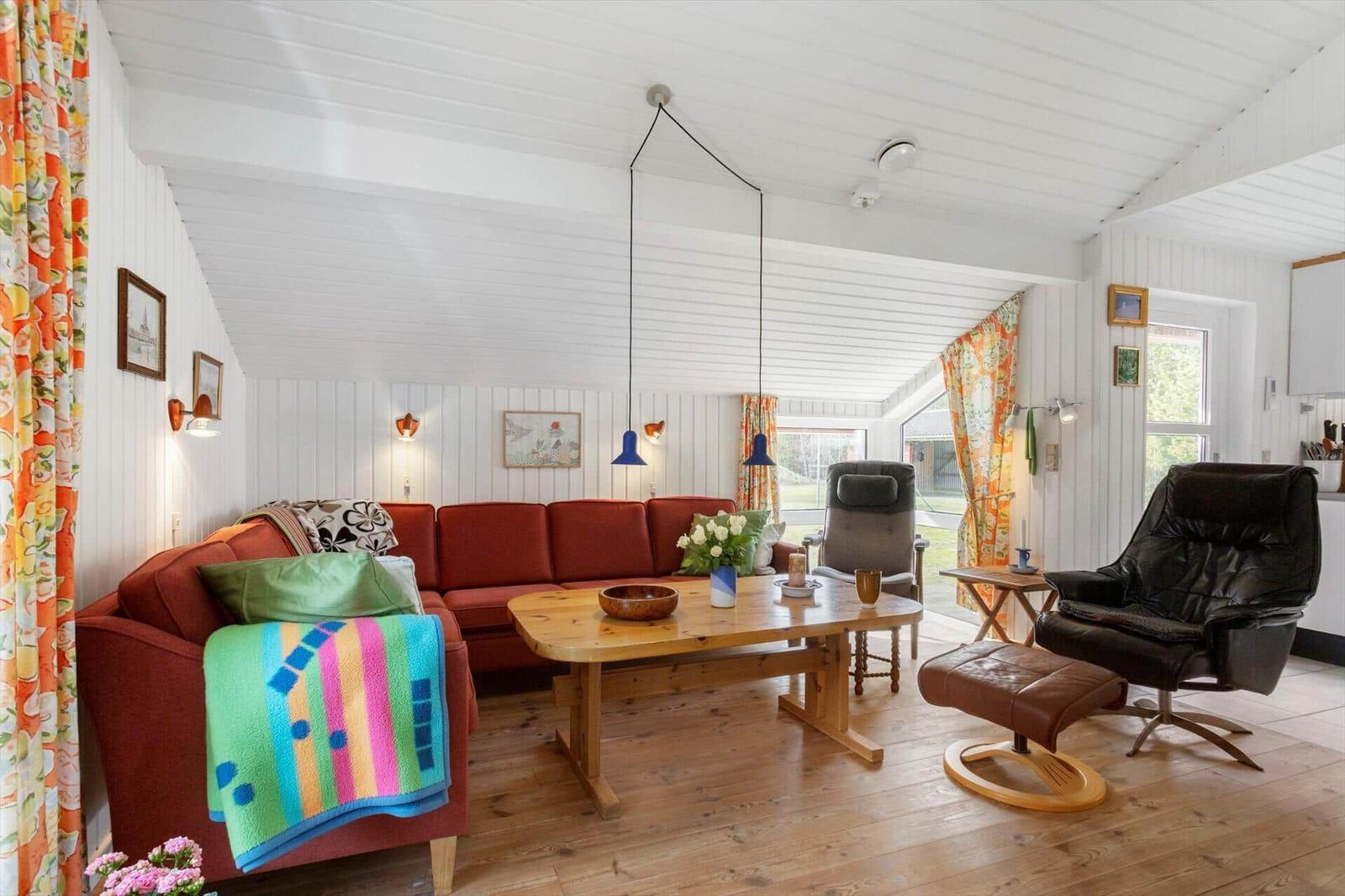 Living room with red sofa, wooden table, and leather recliner.