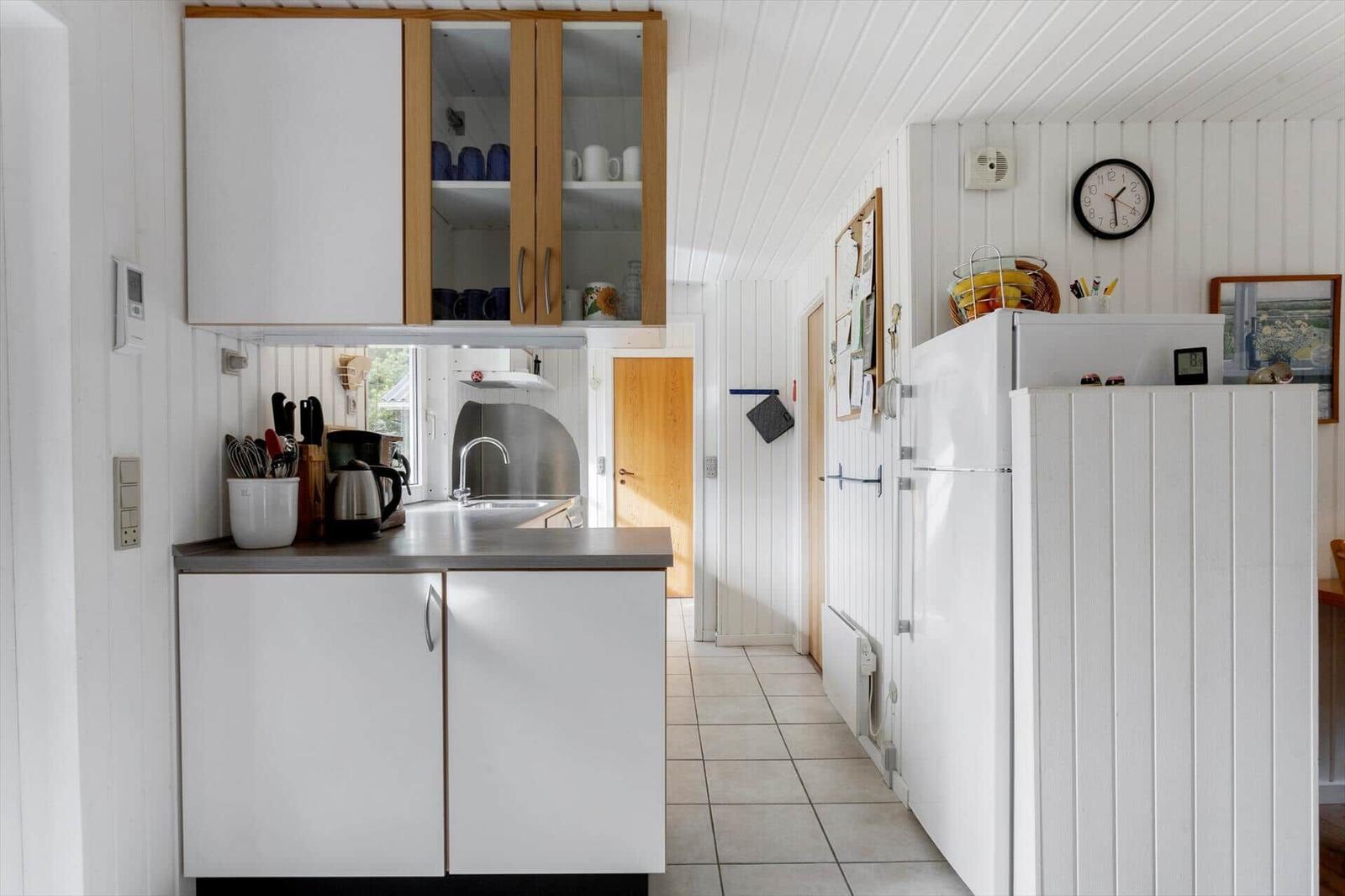 Kitchen with white cabinets, refrigerator, and kitchen counter