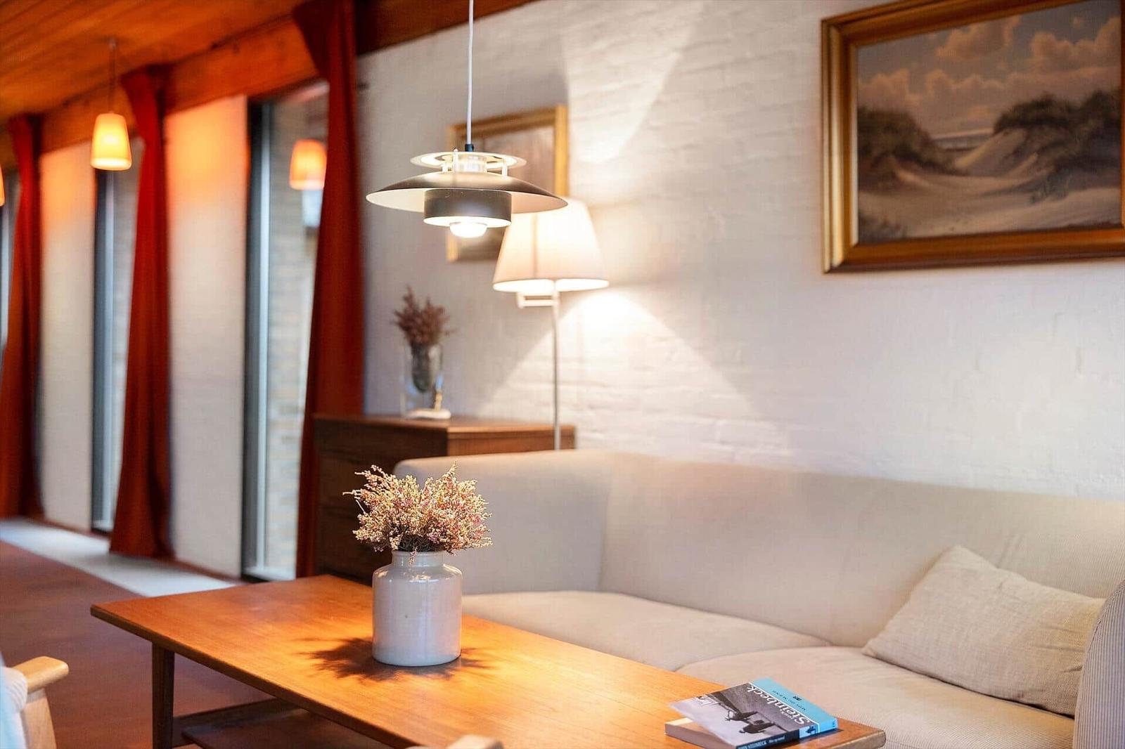 Wohnzimmer mit Sofa, Tisch, Lampe und Bild an der Wand.