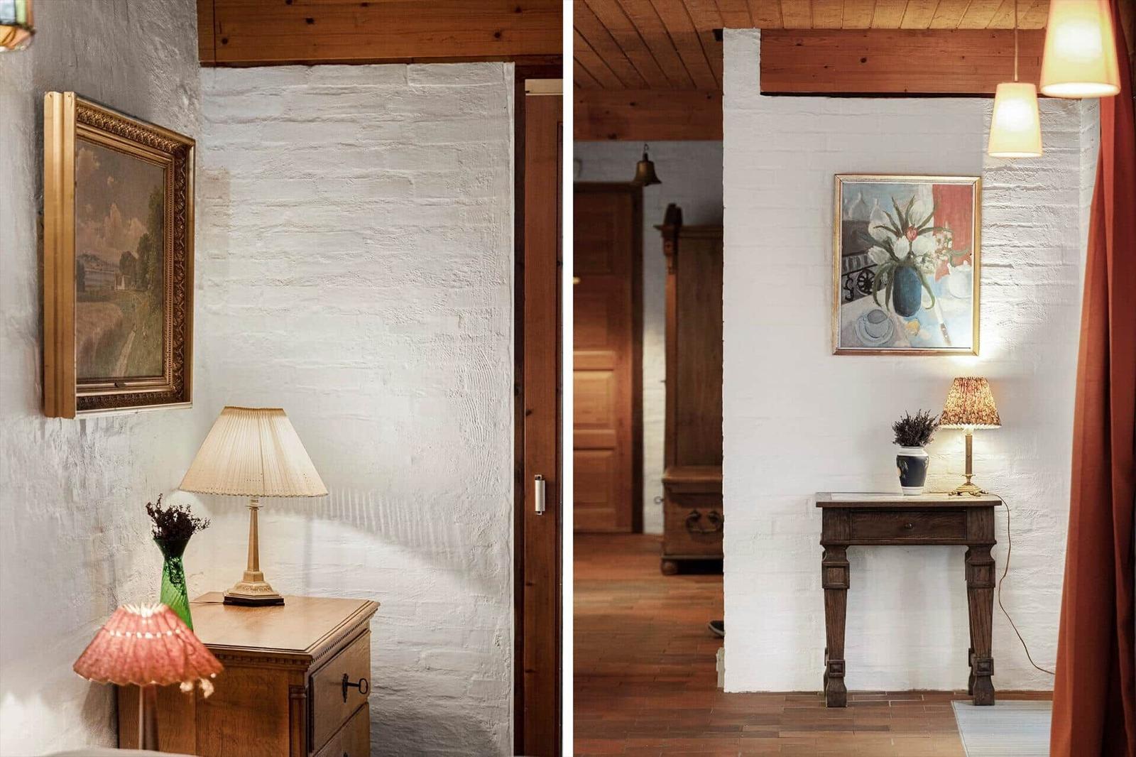 Zwei Räume mit weißen Wänden, Holzboden und Kunstwerken an den Wänden.