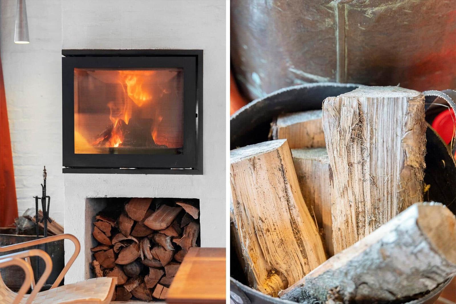 Kamin mit brennendem Holz und Holzstapel daneben