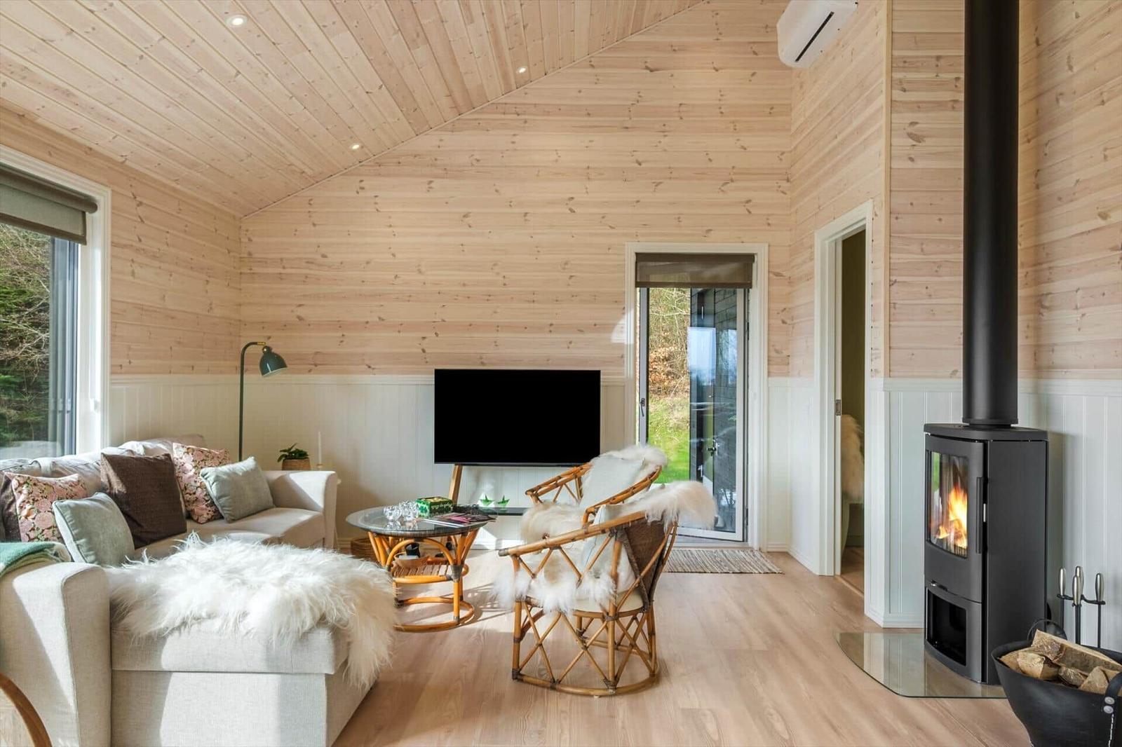 Living room with wooden walls, fireplace, and sofa with fur throw.