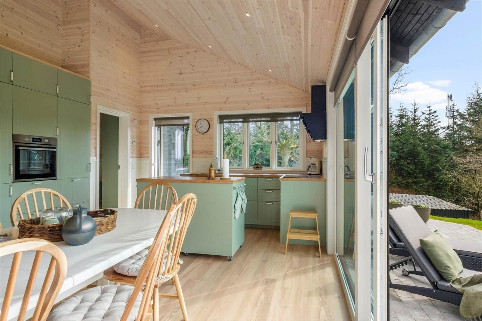 Kitchen with dining area and view of terrace with loungers.