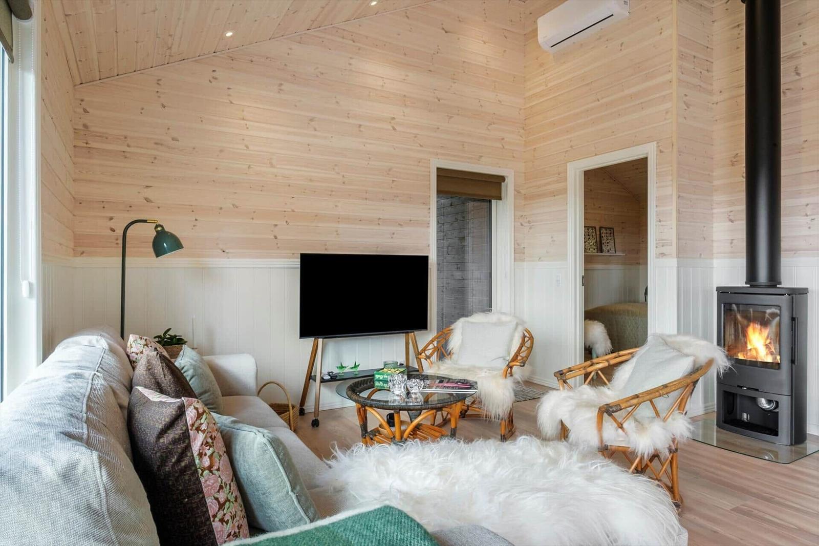 Living room with fireplace, sofa, TV, and chairs.