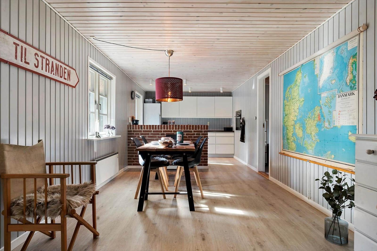 Essbereich mit Tisch, Stühlen und Karte von Dänemark an der Wand.