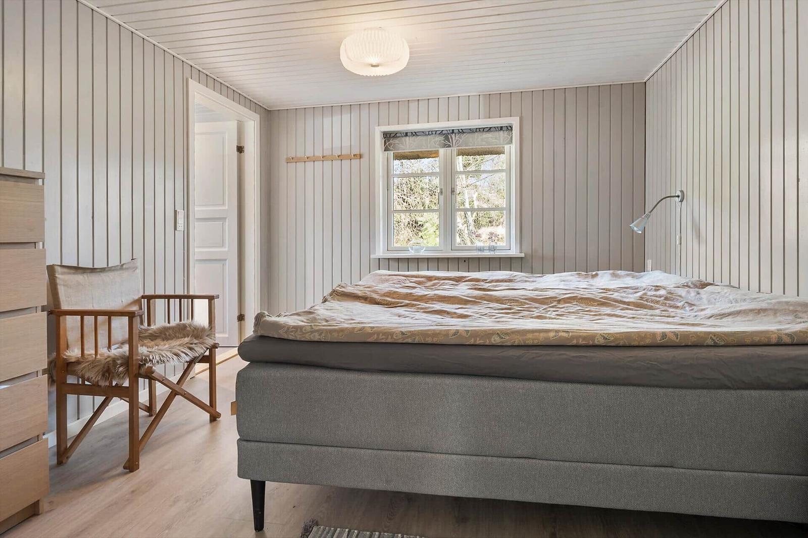 Schlafzimmer mit Bett, Stuhl und Fenster zur Aussicht