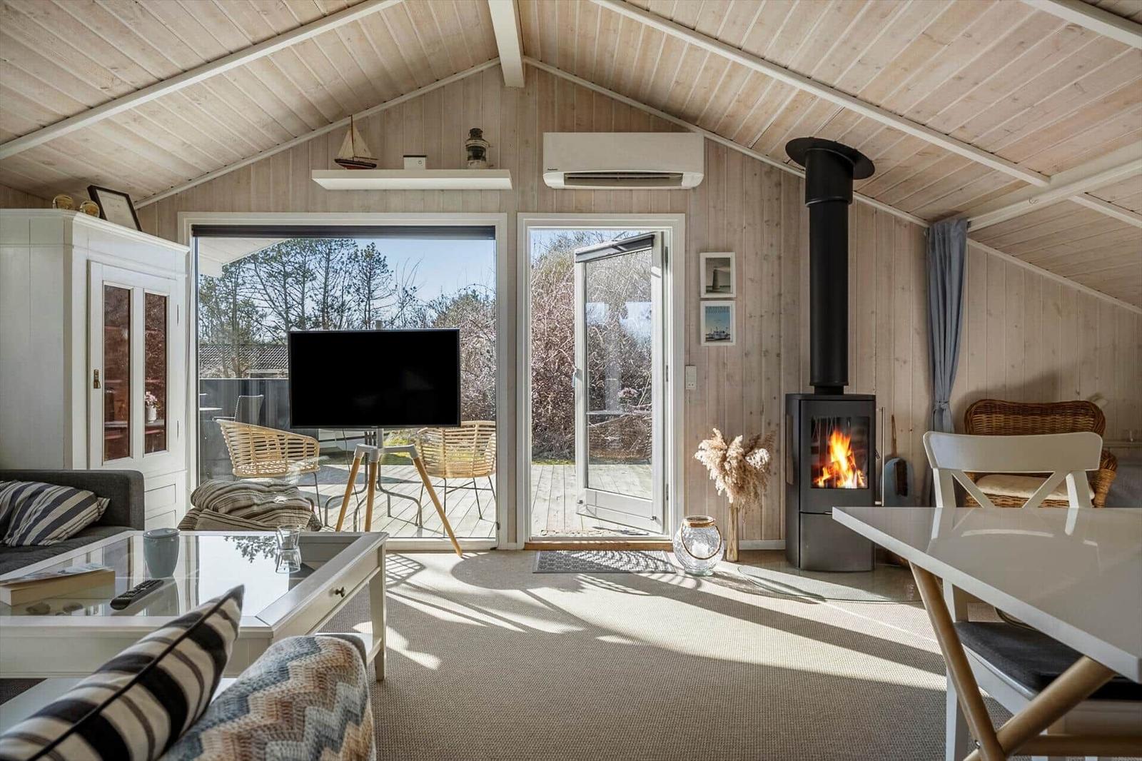 Living room with fireplace, TV, and view of balcony