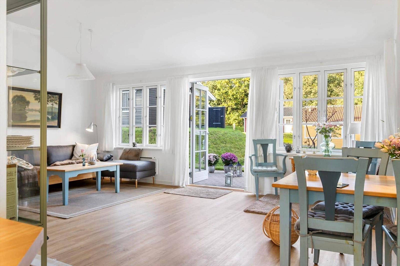 Living and dining area with terrace, windows, and hardwood floor.