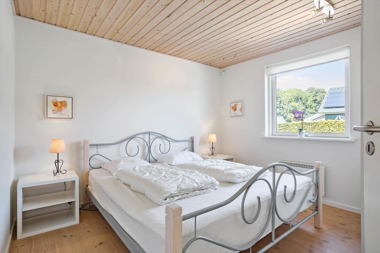 Bedroom with double bed, wooden floor, and window view