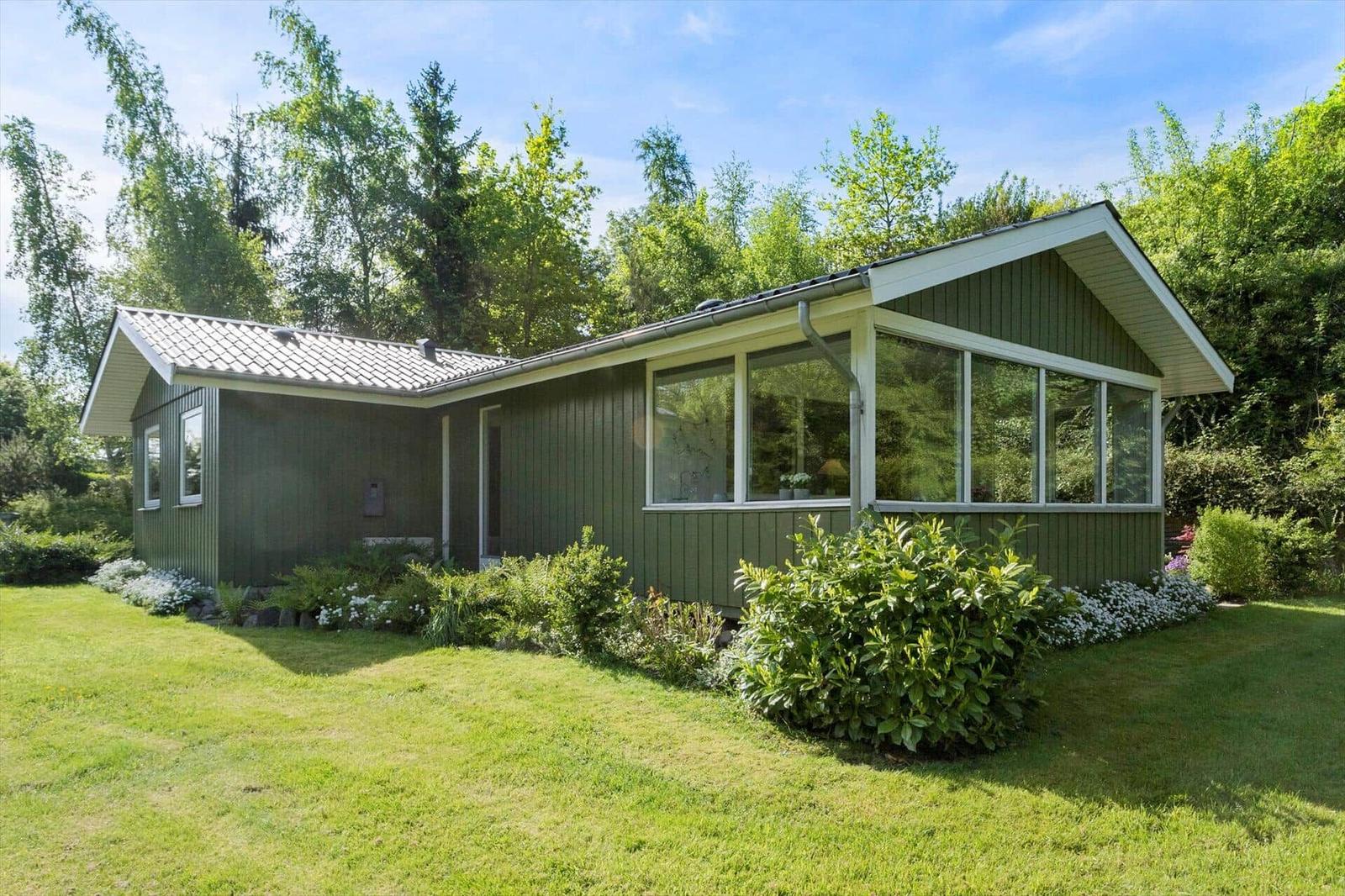 A green house with large windows and garden