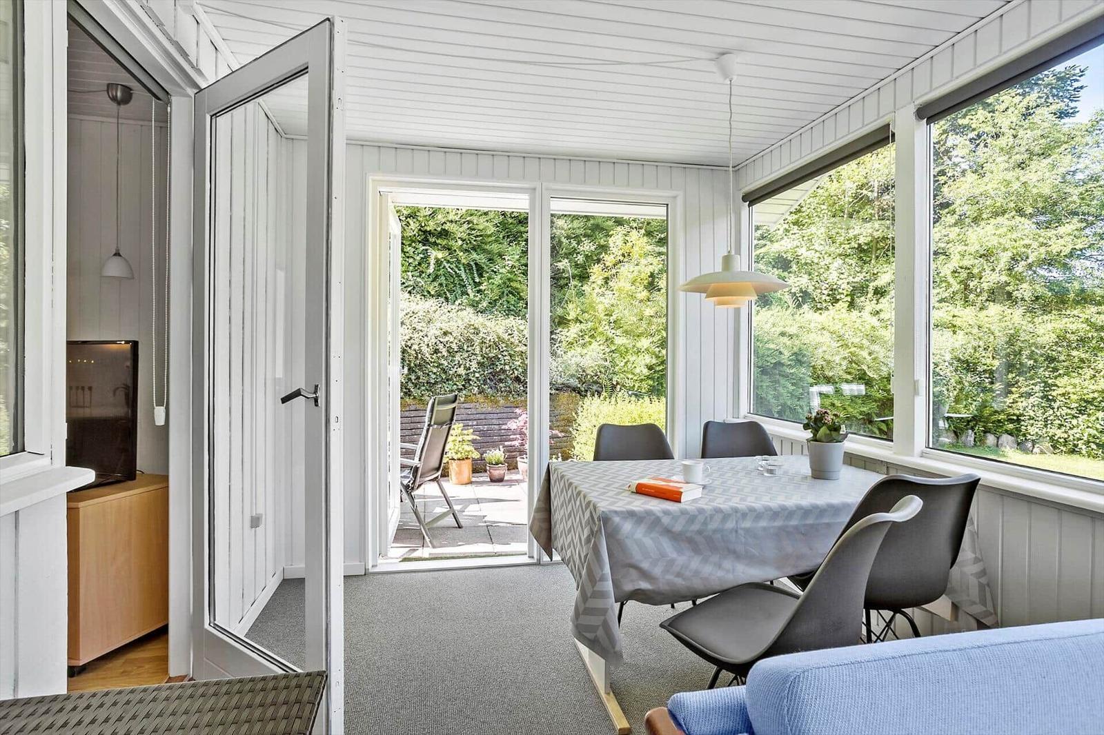 Dining room with table, chairs, and view of garden. Door leads to terrace.