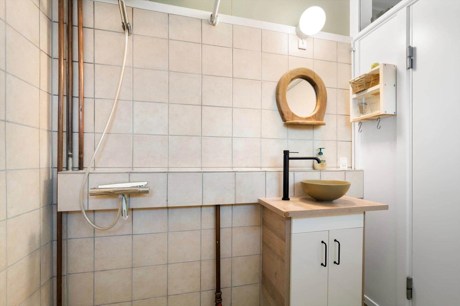 Bathroom with shower, sink, and mirror.